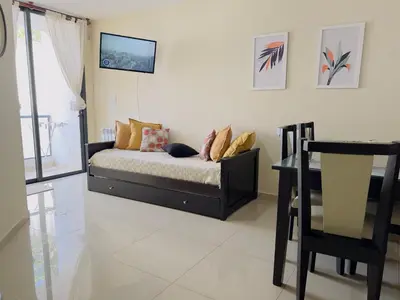 a bedroom with a bed and a chair in it at VOW Departamento CÉNTRICO CON COCHERA in Villa Carlos Paz