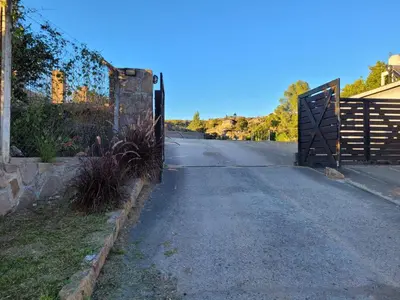 an empty road with a gate on the side of the road at CABAÑAS PIRCAS DE CAMPO in Tanti
