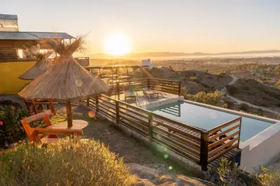 a villa with a swimming pool and a sunset at CABAÑAS PIRCAS DE CAMPO in Tanti