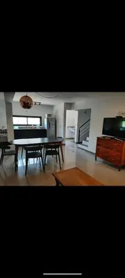 a living room with a table and a piano at Casa Nueva in Villa Rumipal