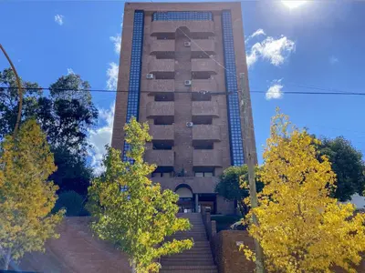 a tall building with trees in front of it at DEPARTAMENTO ROCA in Villa Carlos Paz