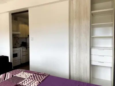 a bedroom with a purple bed and a closet at DEPARTAMENTO ROCA in Villa Carlos Paz