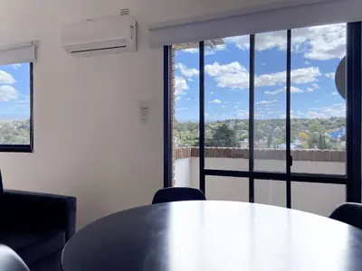 a table and chairs in a room with a large window at DEPARTAMENTO ROCA in Villa Carlos Paz