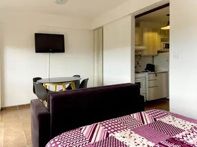 a room with a couch and a table and a kitchen at DEPARTAMENTO ROCA in Villa Carlos Paz