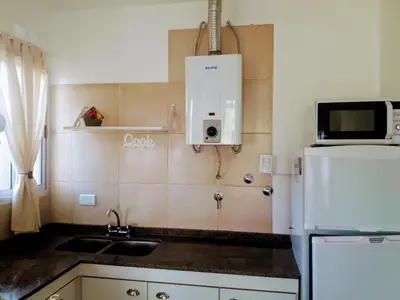 a kitchen with a sink and a white refrigerator at Cabañas Teodoro in Tanti