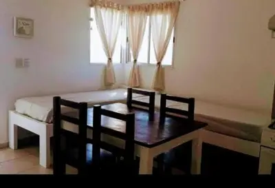 a room with a table and a bed and a window at Cabañas Teodoro in Tanti