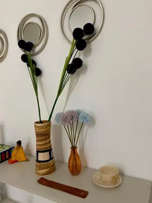 two vases with flowers in them on a shelf at Departamento en Nueva Cordoba Centro Bv Illia in Cordoba