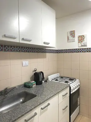 a kitchen with a sink and a stove at Departamento en Nueva Cordoba Centro Bv Illia in Cordoba
