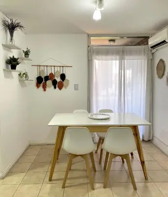 a dining room with a white table and chairs at Departamento en Nueva Cordoba Centro Bv Illia in Cordoba