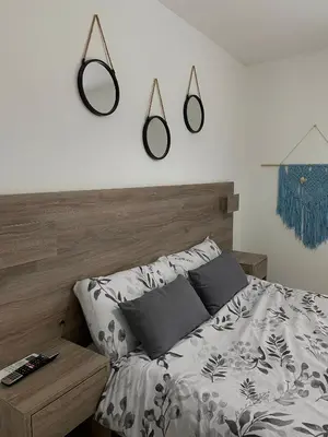 a bedroom with a bed and three mirrors on the wall at Departamento en Nueva Cordoba Centro Bv Illia in Cordoba