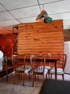 a dining room with a wooden wall with a table and chairs at Casita serrana in Cassaffousth
