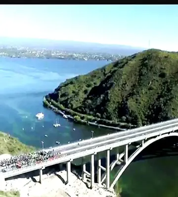a bridge over a river with a bunch of people on it at Casita serrana in Cassaffousth