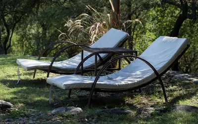 two empty benches sitting in the grass at El Observador del Tiempo in San Javier