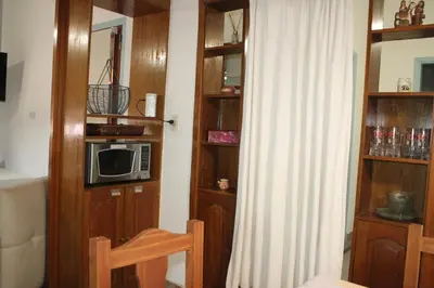a room with a kitchen with a microwave and wooden shelves at Departamento Santa Rosa in Cordoba