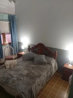 a bedroom with a bed with two lamps on two tables at Departamento Santa Rosa in Cordoba