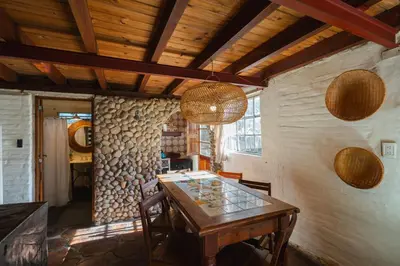 a dining room with a wooden table and chairs at Cabañas La Oma Intiyaco in Atos Pampa