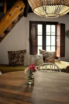 a dining room table with a vase of flowers on it at Cabañas La Oma Intiyaco in Atos Pampa