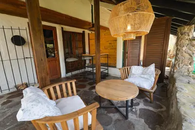 a porch of a house with a table and chairs at Cabañas La Oma Intiyaco in Atos Pampa