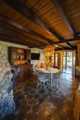 a kitchen and dining room with a table and chairs at Cabañas La Oma Intiyaco in Atos Pampa