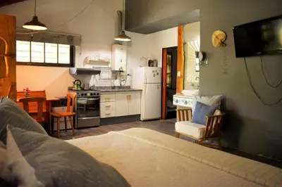 a kitchen and living room with a bed in a room at Cabañas La Oma Intiyaco in Atos Pampa