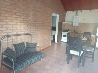 a living room with a couch and a table and a kitchen at Cabañas Nicasio in Merlo