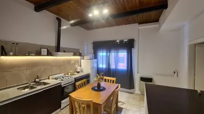a kitchen with a table and a sink and a stove at LitStay Paso de los Andes PA in Cordoba