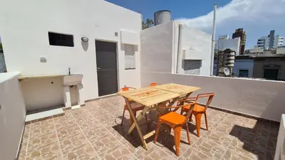 a wooden table and chairs on a balcony at LitStay Paso de los Andes PA in Cordoba