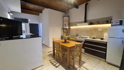 a kitchen with a table and a stove and a refrigerator at LitStay Paso de los Andes PA in Cordoba