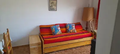 a couch with colorful pillows in a room at Departamento pleno centro de Villa Carlos Paz in Villa Carlos Paz