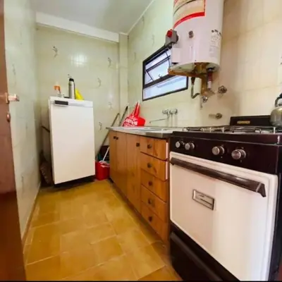 a kitchen with a stove and a refrigerator at Departamento pleno centro de Villa Carlos Paz in Villa Carlos Paz