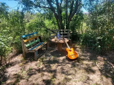 a picnic table and a guitar sitting next to a bench at Sacha Manta in Mina Clavero