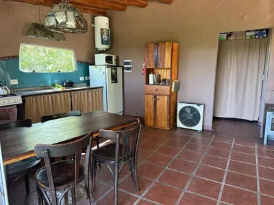 a kitchen with a wooden table and chairs at Sacha Manta in Mina Clavero