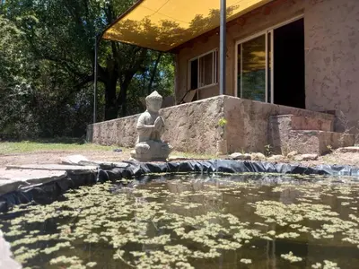 a statue sitting in front of a pool of water at Sacha Manta in Mina Clavero
