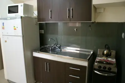 a kitchen with a sink and a white refrigerator at DERC Temporarios in Río Cuarto