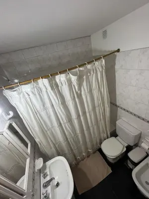 a bathroom with a toilet and a sink and a shower curtain at Montevideo 20 Bis in Cordoba