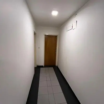 a hallway with white walls and a brown door at Montevideo 20 Bis in Cordoba