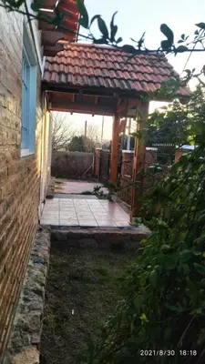 a wooden pergola on the side of a house at Cabañas Los Cerezos in Mina Clavero