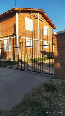 a black fence in front of a building at Cabañas Los Cerezos in Mina Clavero