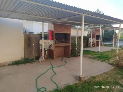 a patio with awning and a grill with a stove at Cabañas Los Cerezos in Mina Clavero
