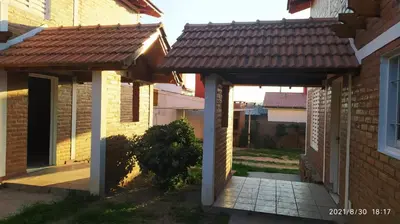 a brick house with awnings and a patio at Cabañas Los Cerezos in Mina Clavero