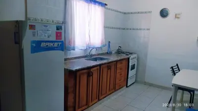a small kitchen with a sink and a refrigerator at Cabañas Los Cerezos in Mina Clavero