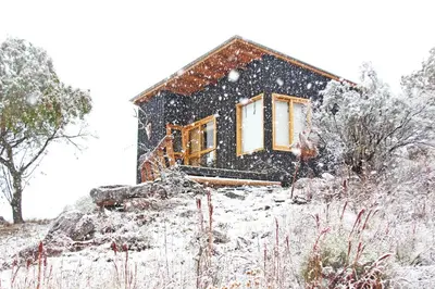 a house on a hill with snow on it at Fase a Tierra in Atos Pampa