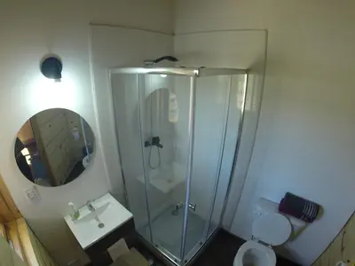 a bathroom with a shower and a toilet and a sink at Fase a Tierra in Atos Pampa