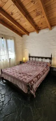 a large bed in a room with a wooden ceiling at Chalet exclusivo en Tanti, Córdoba in Tanti