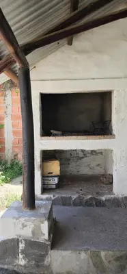 a stone fireplace in a building with a roof at Chalet exclusivo en Tanti, Córdoba in Tanti