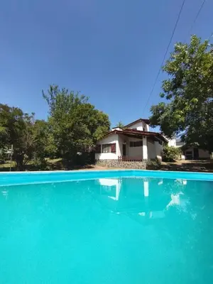 a house and a swimming pool with blue water at Chalet exclusivo en Tanti, Córdoba in Tanti