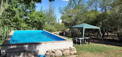 a swimming pool with a table and an umbrella at Chalet exclusivo en Tanti, Córdoba in Tanti