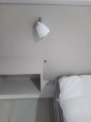 a white bedroom with a bed and a table with a lamp at Tranquilidad, privacidad y relax in Cordoba