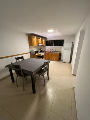 a kitchen with a table and chairs in a room at Casa Villa CARLOS PAZ CERCA DE COSTANERA in Villa Carlos Paz