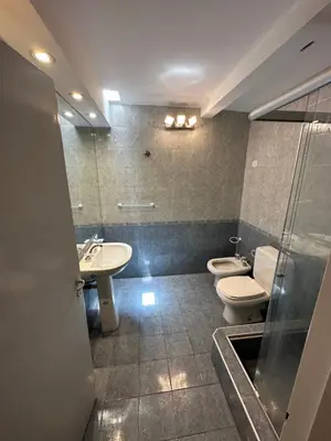 a bathroom with two toilets and a sink and a shower at Casa Villa CARLOS PAZ CERCA DE COSTANERA in Villa Carlos Paz